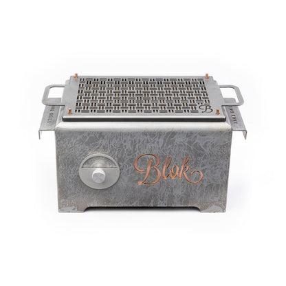View of the Blok Hako Patina Table Grill in a backyard setting